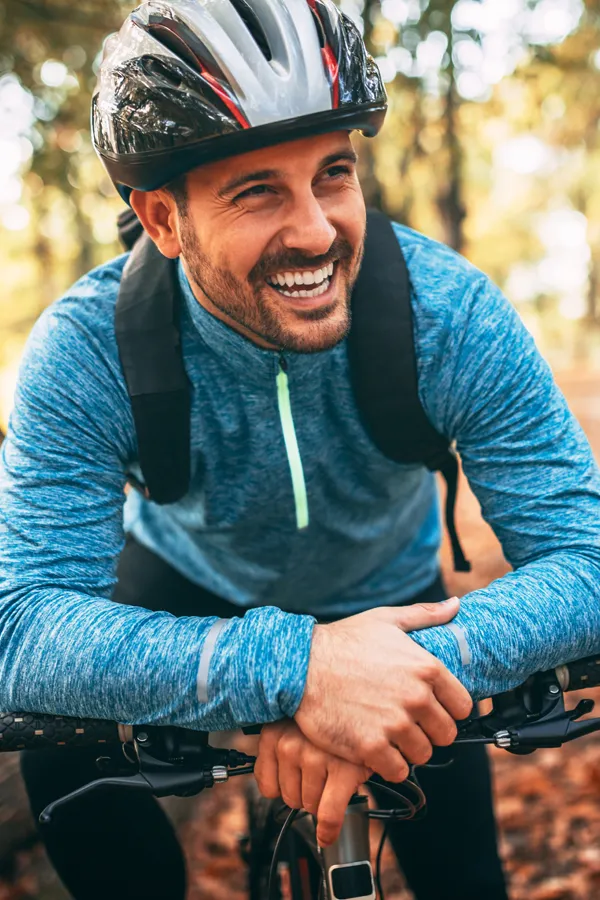 Adrenal-Hormone-Disorder-Treatment A smiling man getting ready for a cycling trip. Get treatment for adrenal hormone disorder from Morgan Burns, APRN in Central Florida.