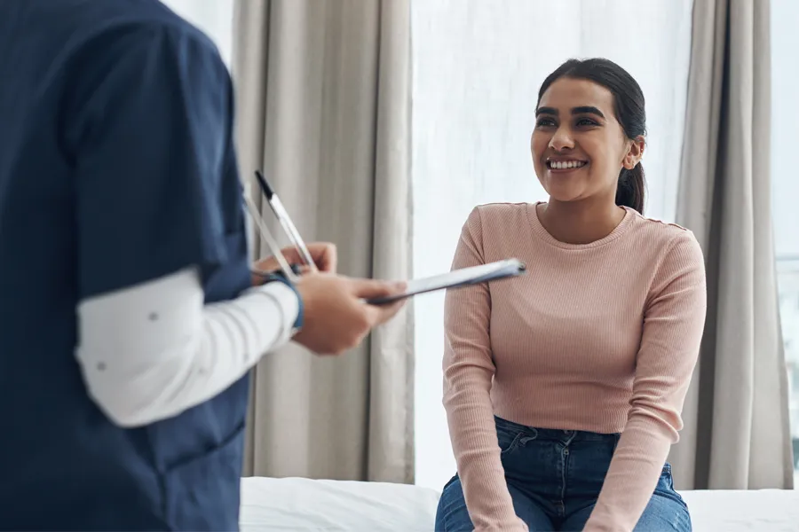 Adult-Physical-Exam-Clinic A woman speaks to a clinician before a physical exam. Get adult physical exams from Morgan Burns, APRN in Central Florida.