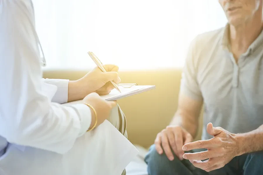 Annual-Wellness-Exams-Clinic-e1769717650117 A clinician takes notes while speaking with a patient. Schedule an annual wellness exam from Morgan Burns, APRN in Central Florida.