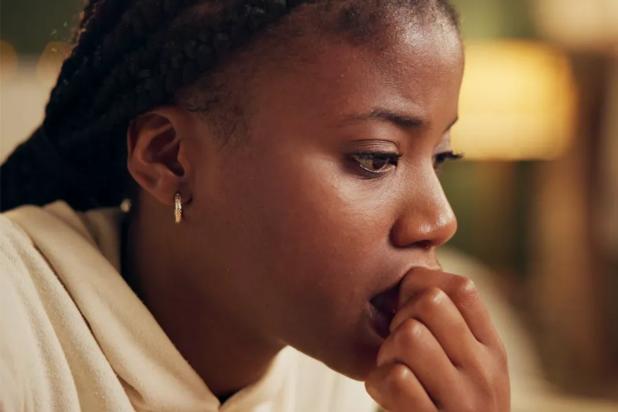 Anxiety-Clinic A black woman bites her nails with worry. Get treatment for anxiety from Morgan Burns, APRN in Central Florida.