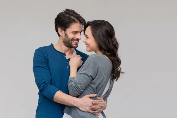 Erectile-Dysfunction-Doctor A man in a blue shirt embracing a woman in a gray shirt smiles due to his successful erectile dysfunction care from Morgan Burns, APRN in Central Florida.