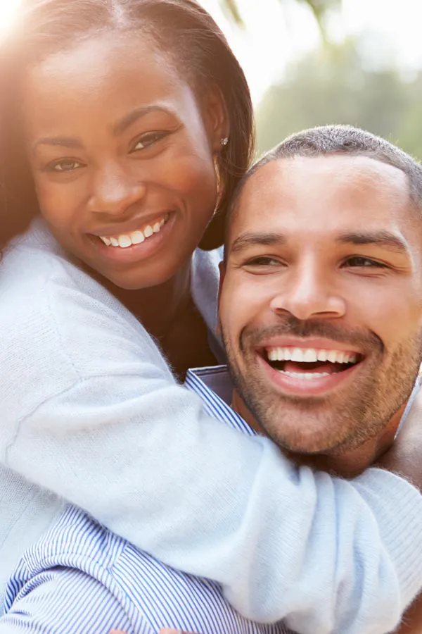 Erectile-Dysfunction-Treatment A woman riding on a man's back, both smiling due to help with erectile dysfunction from Morgan Burns, APRN in Central Florida.