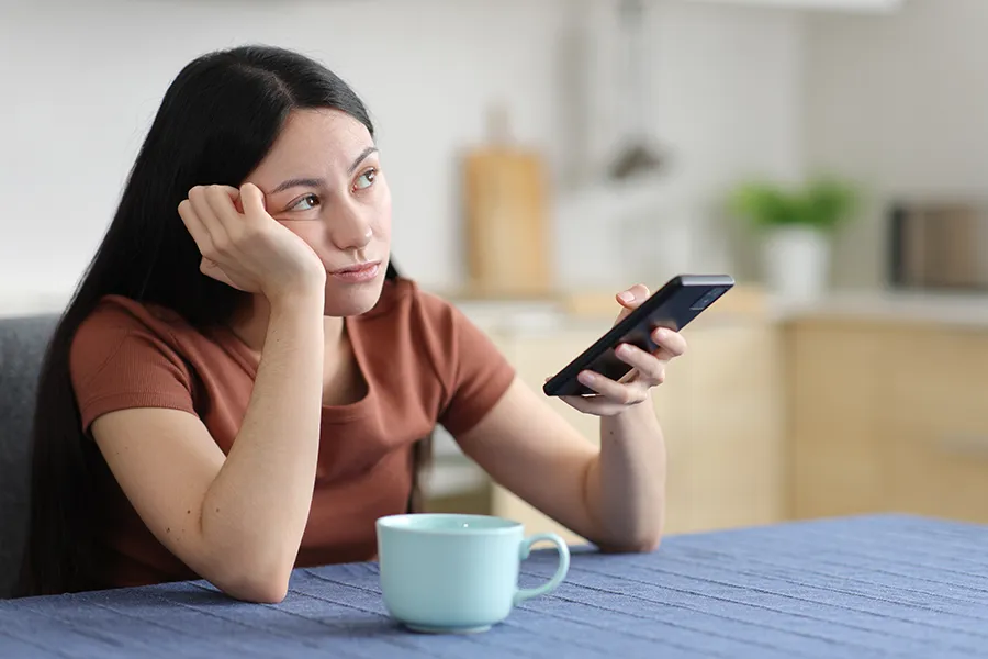 Focus-Issues-Clinic A woman stares into space with her phone in hand. Get treatment for focus issues from Morgan Burns, APRN in Central Florida.
