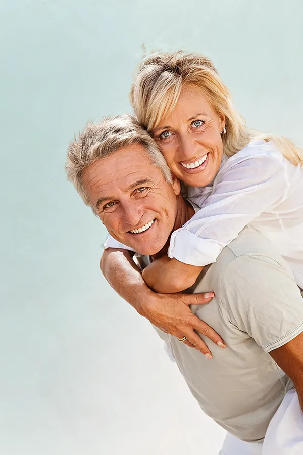 Food-Allergies-Treatment-1 A happy mature couple having fun - the husband is carrying his wife on his back. Get treatment for food allergies from Morgan Burns, APRN in Central Florida.