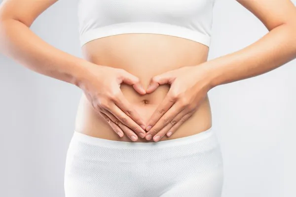 Gut-Repair-Peptides-Clinic A woman holds her hands over her belly in a heart shape. Get Gut Repair Peptides treatment from Morgan Burns, APRN in Central Florida.
