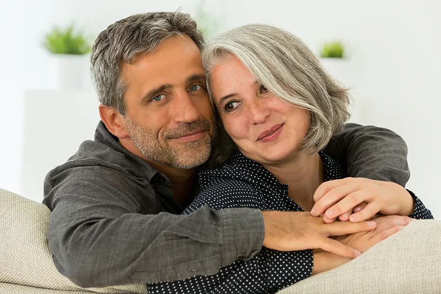 Hormonal-and-Vitality-Peptides-Clinic A middle-aged couple holding each other on the couch. Get Hormonal and Vitality Peptide Treatment from Morgan Burns, APRN in Central Florida.