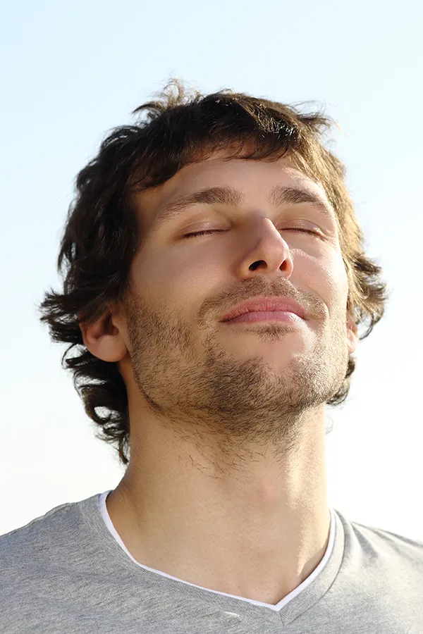 Lupus-Treatment A brown-haired man closes his eyes and breathes in fresh air with his face turned up to the sky. Get treatment for Lupus from Morgan Burns, APRN in Central Florida.