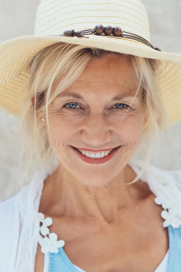 Menopause-Treatment A beautiful, smiling older woman with blonde hair and a sunhat, happy with menopause treatment from Morgan Burns, APRN in Central Florida.