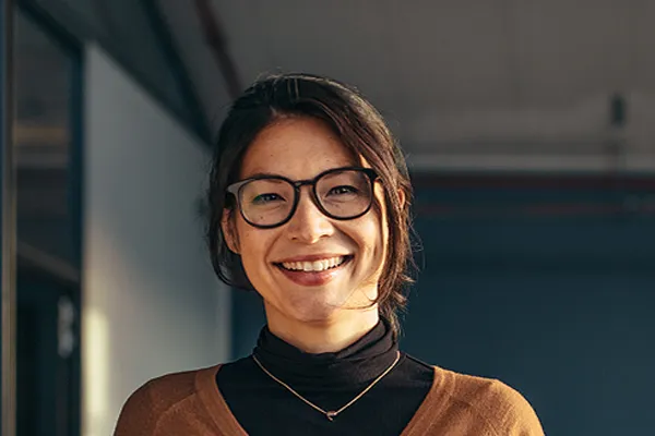 Metabolic-Syndrome-Clinic A brunette woman with glasses smiles in a gray-blue walled office. Get metabolic syndrome from Morgan Burns, APRN in Central Florida.