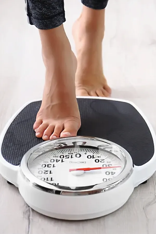 Metabolilc-and-Weight-Optimization-Peptides-Treatment A woman steps onto a scale. Get Metabolilc and Weight Optimization Peptides treatment from Morgan Burns, APRN in Central Florida.