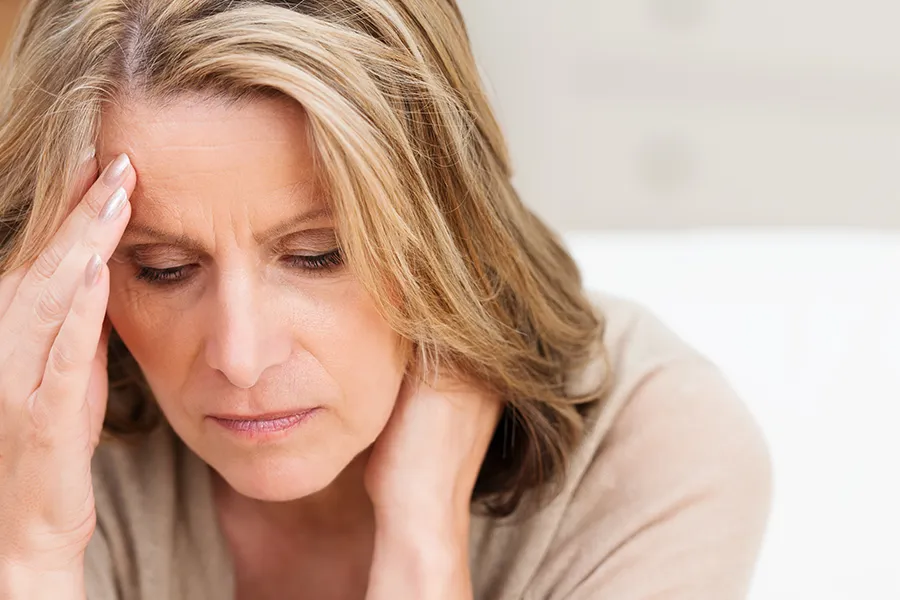 Mood-Imbalances-Clinic-2 A woman rubs her forehead with worry. Schedule treatment for mood imbalances from Morgan Burns, APRN in Central Florida.