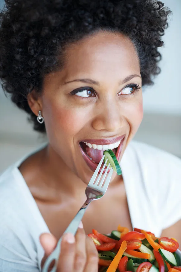 Natural-Detoxification-Treatment A Black woman smiles while eating a healthy salad. Get natural detoxification treatment from Morgan Burns, APRN in Central Florida.