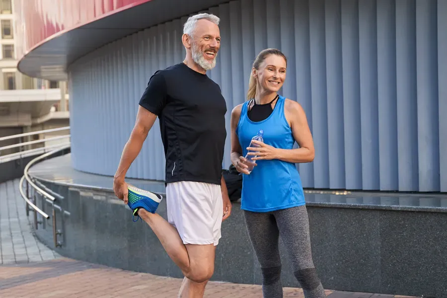 Peptides-for-Healing-and-Recovery-Doctor A middle-aged couple happily stretch and prepare for exercise after receiving effective peptide therapy for healing and recovery from Morgan Burns, APRN in Central Florida.