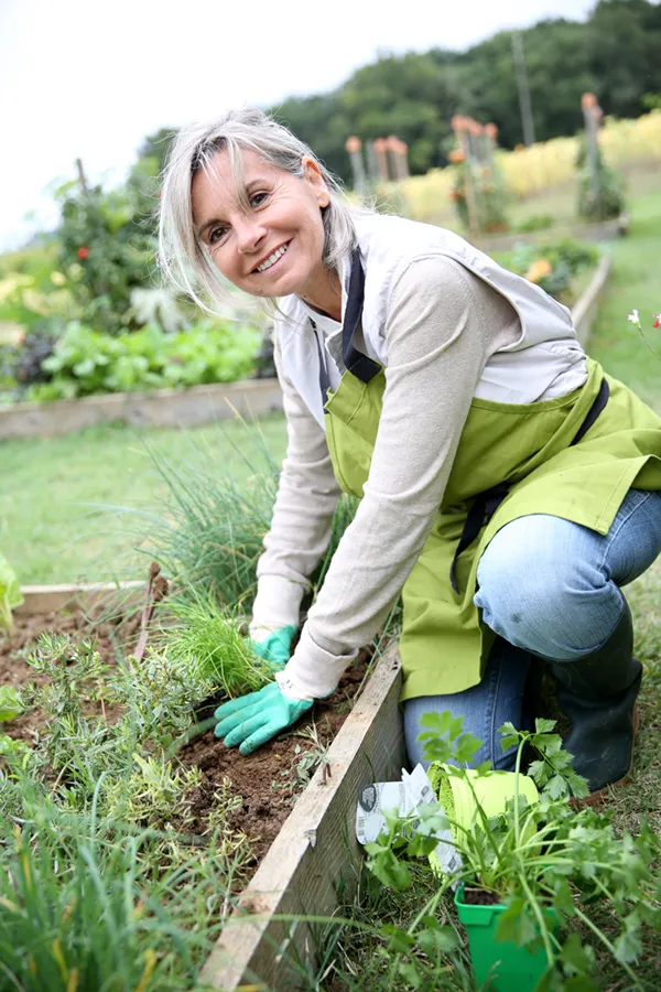 Rheumatoid-Arthritis-Treatment A mature woman bending down working on her garden happily after successful rheumatoid arthritis treatment from Morgan Burns, APRN in Central Florida.