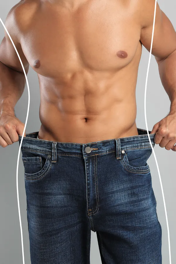 Semaglutide-Weight-Loss-Treatment A strong shirtless man in jeans holds the waistlines of his too-big jeans to show the success of semaglutide weight loss from Morgan Burns, APRN in Central Florida.