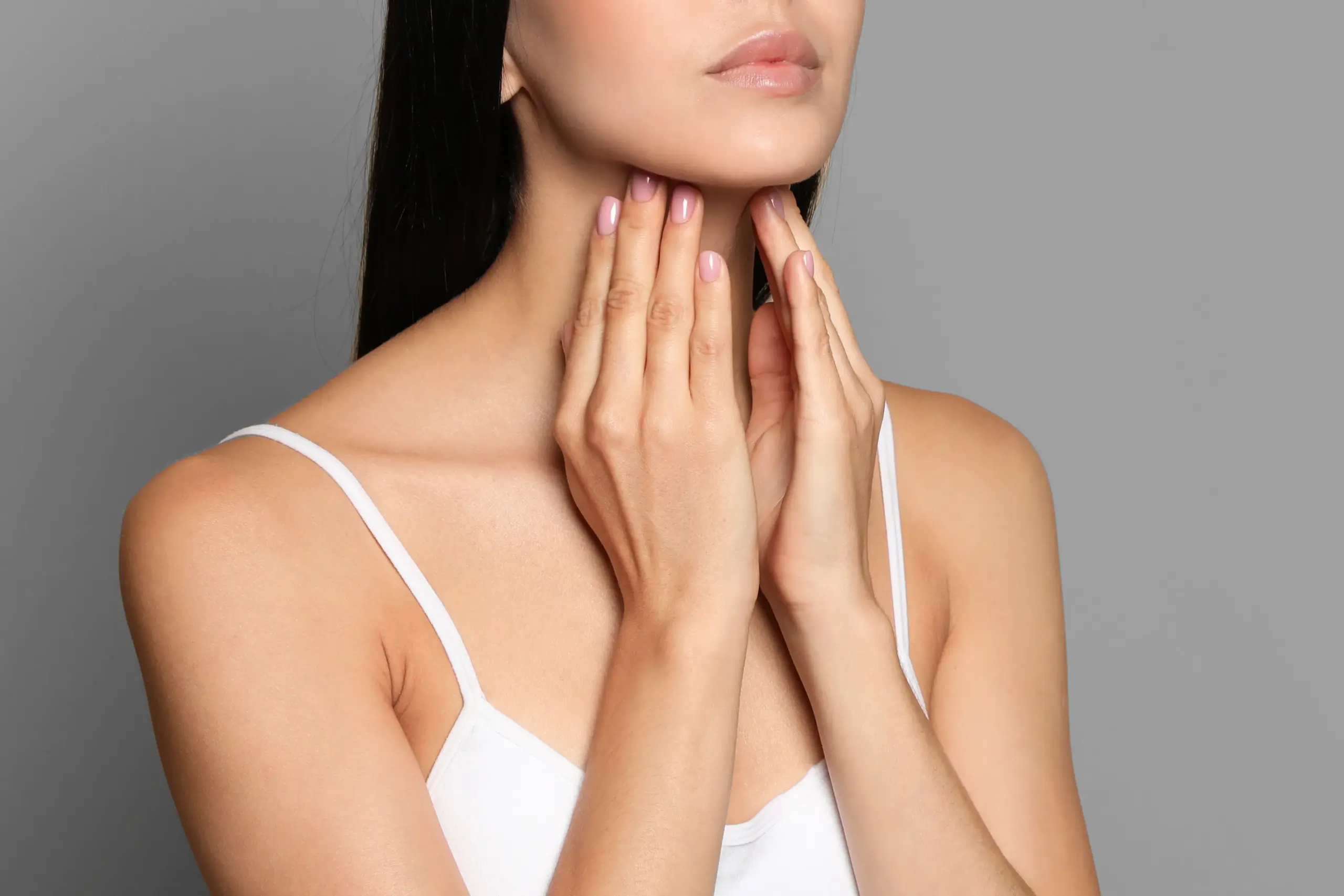 Thyroid-Doctor A woman in a white tank top touches her neck looking for signs of thyroid disorder. Get help for thyroid disorders from Morgan Burns, APRN in Central Florida.